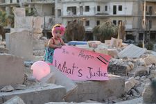 Sama pictured in September 2016, in the bombarded east of the city with a placard in response to US presidential candidate Gary Johnson’s infamous gaffe “What’s Aleppo?”