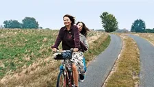 Betty (Barbara Auer) with Laura (Paula Beer) on the bicycle