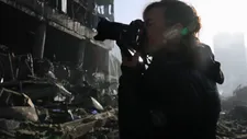 Lynsey Addario photographs a damaged building in Ukraine