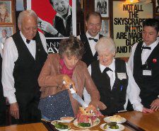 Carnegie Deli staff assisting Dena Kaye with the first cutting of the Danny Kaye