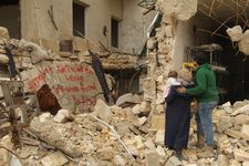 Waad, Hamza and Sama look at graffiti they painted on a bombed-out building, protesting against the forced exile of the civilian population of east Aleppo by forces of the Syrian regime and their Russian and Iranian allies, December 2016