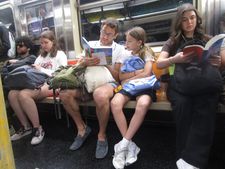 A father reads Astrid Lindgren’s Wir Kinder Aus Bullerbü to his daughter on the NYC subway