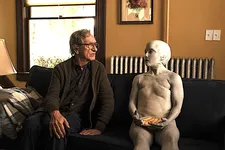 Jules (Jade Quon) with a plate full of apple slices listening to Milton (Ben Kingsley)