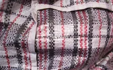 When Sam (Yahya Mahayni) is hiding on the back of the truck, he is wearing a plaid shirt among the blue plaid bags.