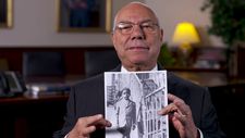 Colin Powell holding a photo of himself, c. 1943 in The Automat