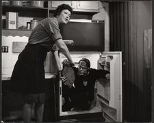 Member of the crew comes out of the refrigerator to hand Julia Child a fish