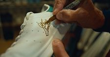 Stan Smith signing a Stan Smith sneaker
