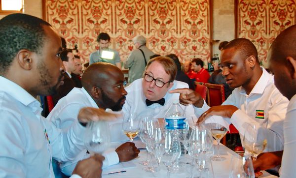 Team Zimbabwe - Tinashe Nyamudoka, Pardon Taguzu, Joseph Dhafana, and Marlvin Gwese in discussion with coach Denis Garret in the middle at the fifth World Wine Tasting Championships.